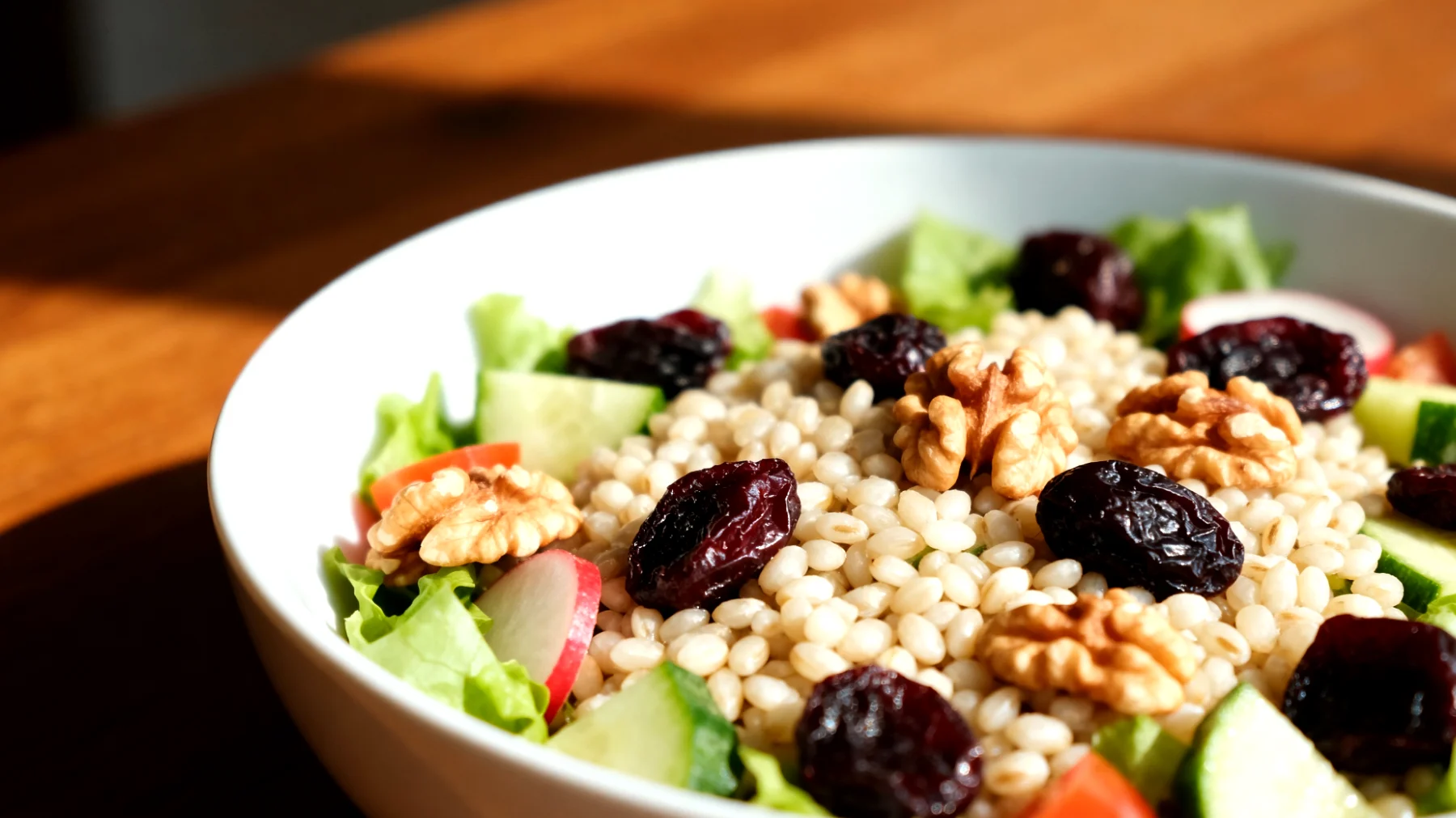 Insalata di orzo perlato con prugne secche, noci e verdure crude"